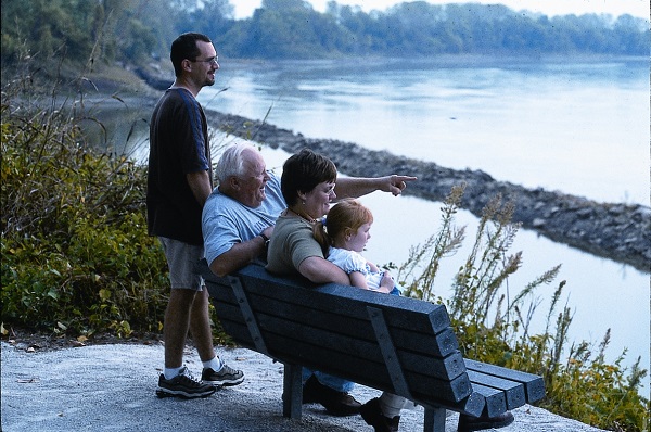 a group of people take a break on a bench overlooking the Missouri River