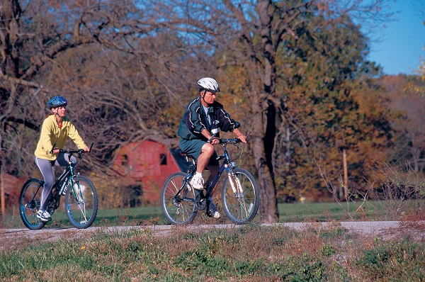 Two bicyclists riding past a barn on Katy Trail State Park