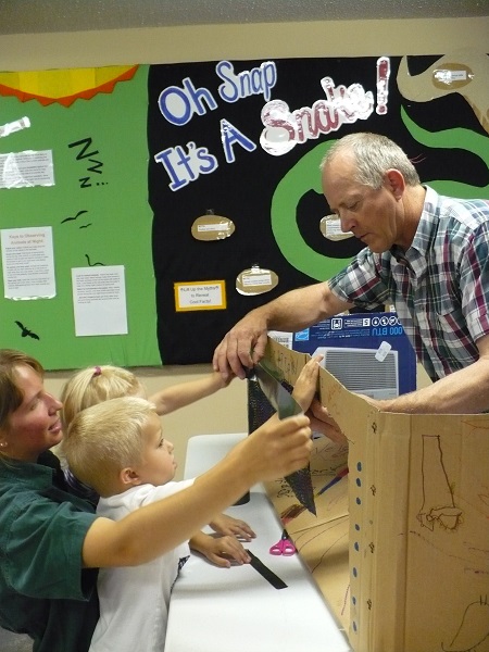 a park employee helping some kids with an exhibit