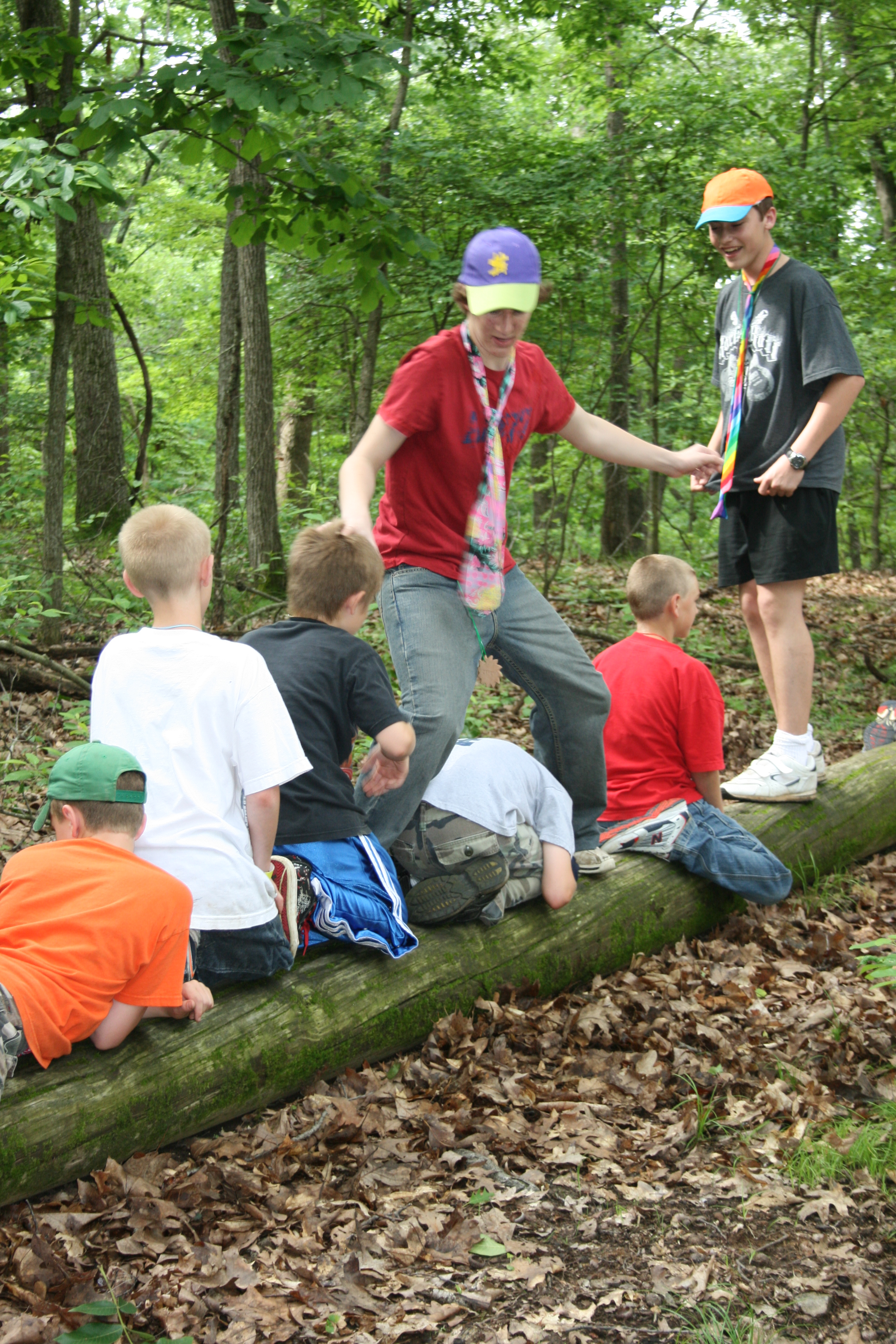 Kids on a log work on a team building activity 