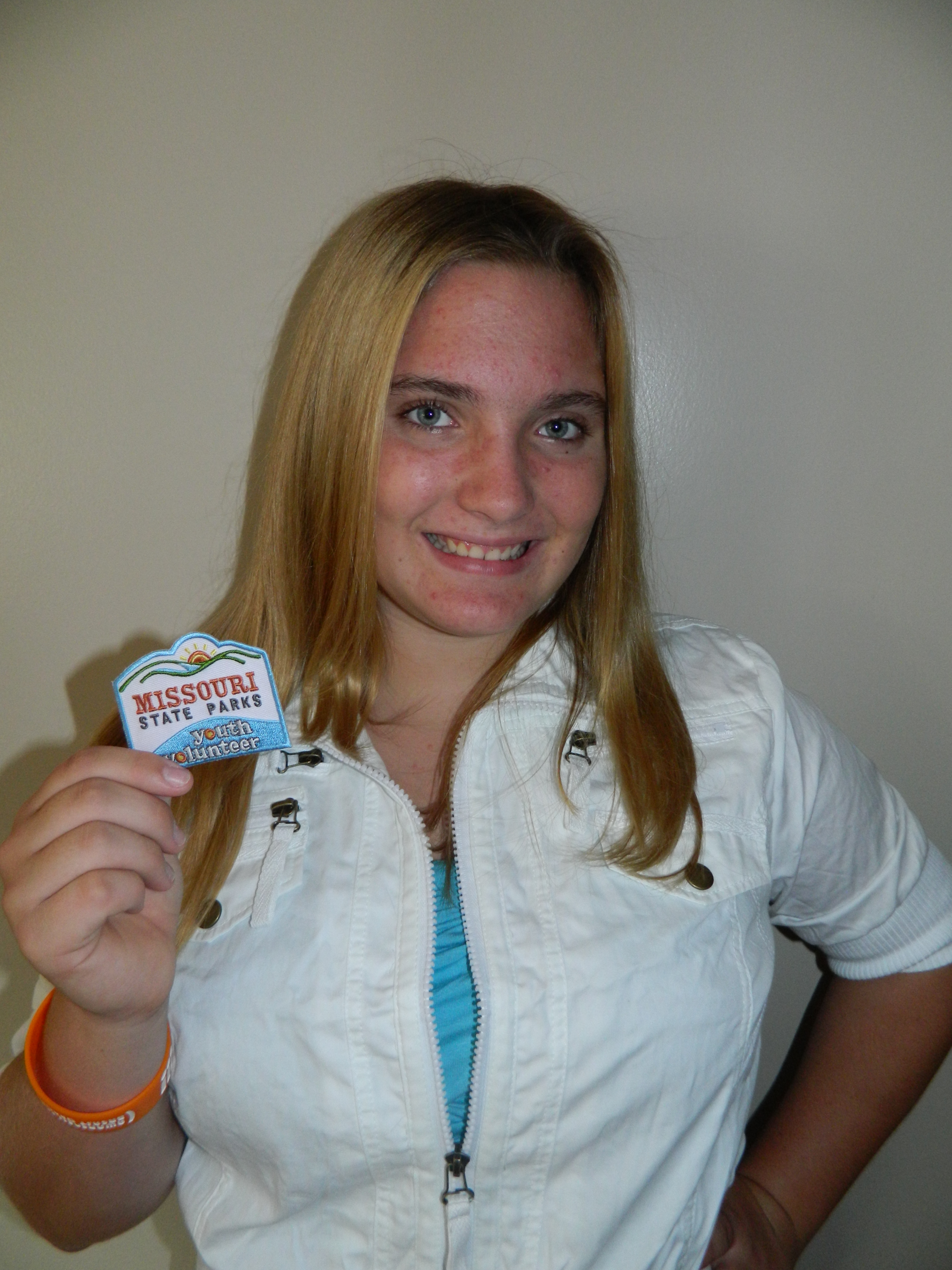 a young girl showing off the patch she earned
