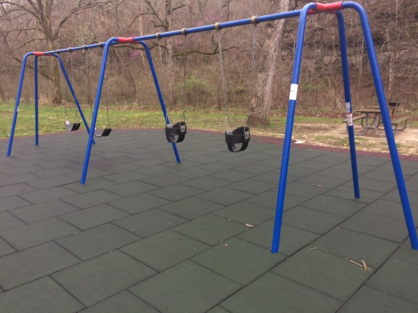 swings on cushioned playground area