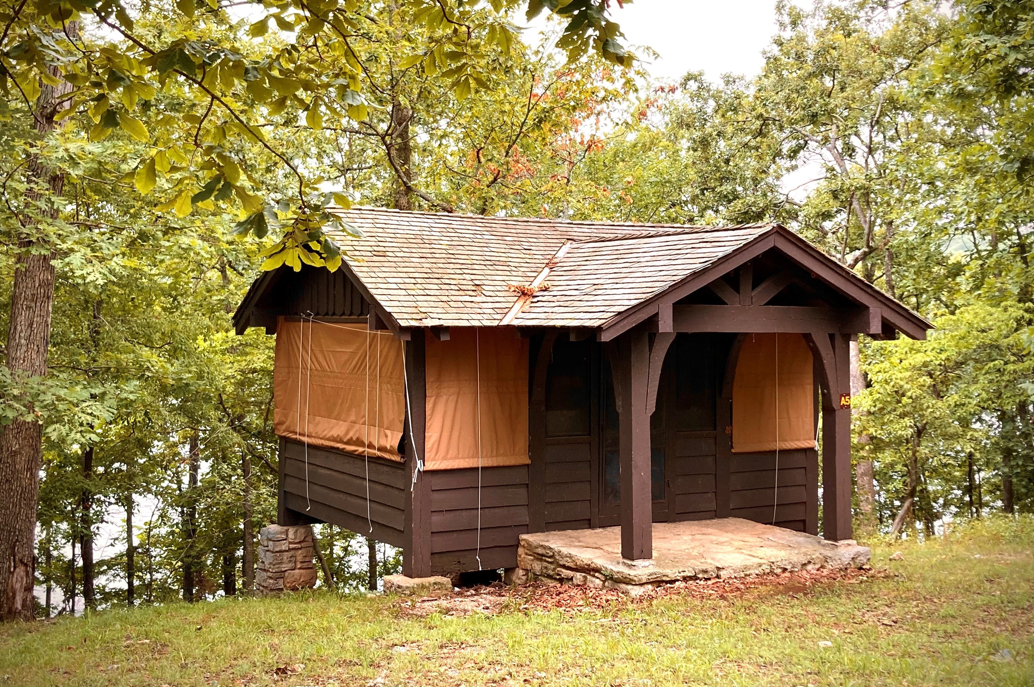 Cabin on ridge with lake in the background and trees surrounding