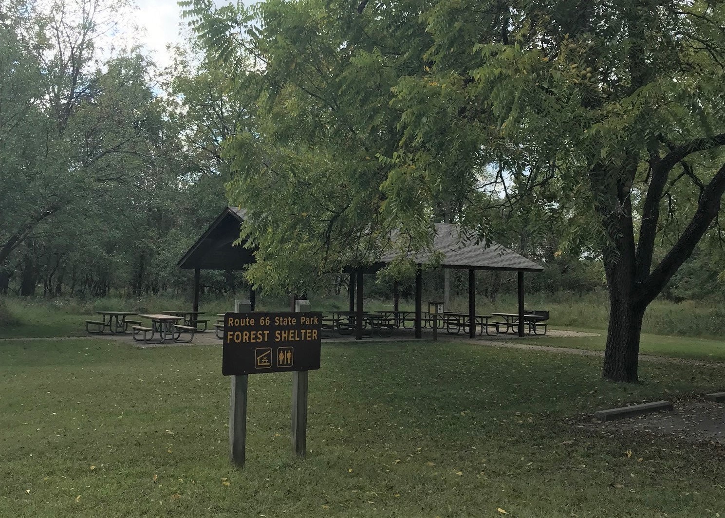 Open picnic shelter with "FOREST SHELTER" sign in foreground