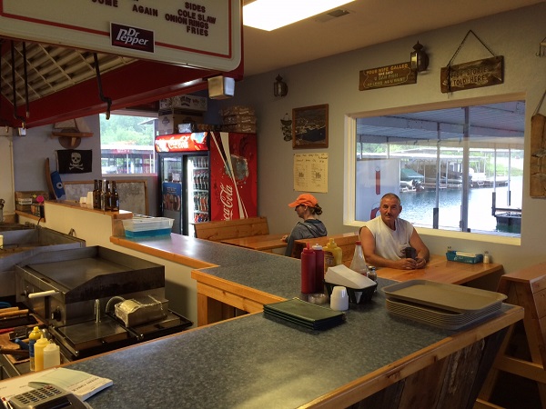 two people sitting at tables in the dining area of the marina