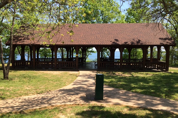 sidewalk leads to water fountain ans shelter next to the lake