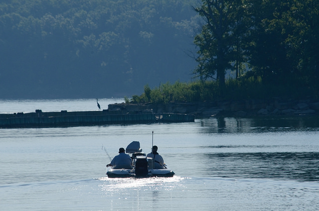 two men fishing from a boat on the lake