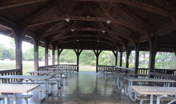 Picnic tables under the roof of the open shelter