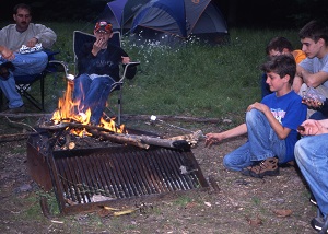 a family sitting around a campfire