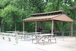open shelter with large grills  and tables next to the enclosed shelter