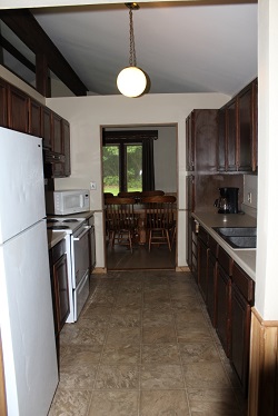 kitchen with stove, refridgerator and sinks inside a cabin