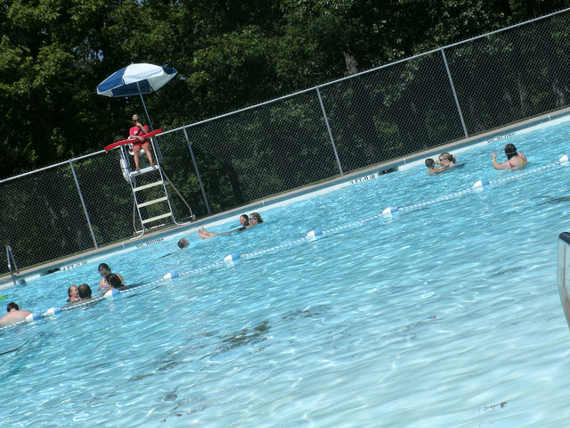 lifeguard watching people swim in the pool 